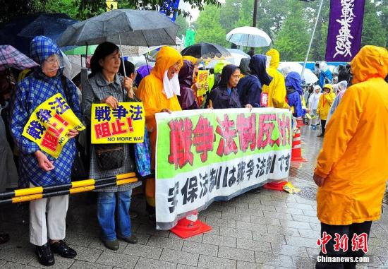 随着安倍阵营强推以解禁集体自卫权为核心内容的安保法案最终过关的计划进入“倒计时”，日本民众的反安保抗议活动再度进入高潮。在之前彻夜抗议之后，9月17日白天，又有众多日本民众冒着大雨持续聚集在国会周边进行抗议活动。中新社发 王健 摄