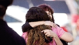 人们在枪击现场附近相互拥抱