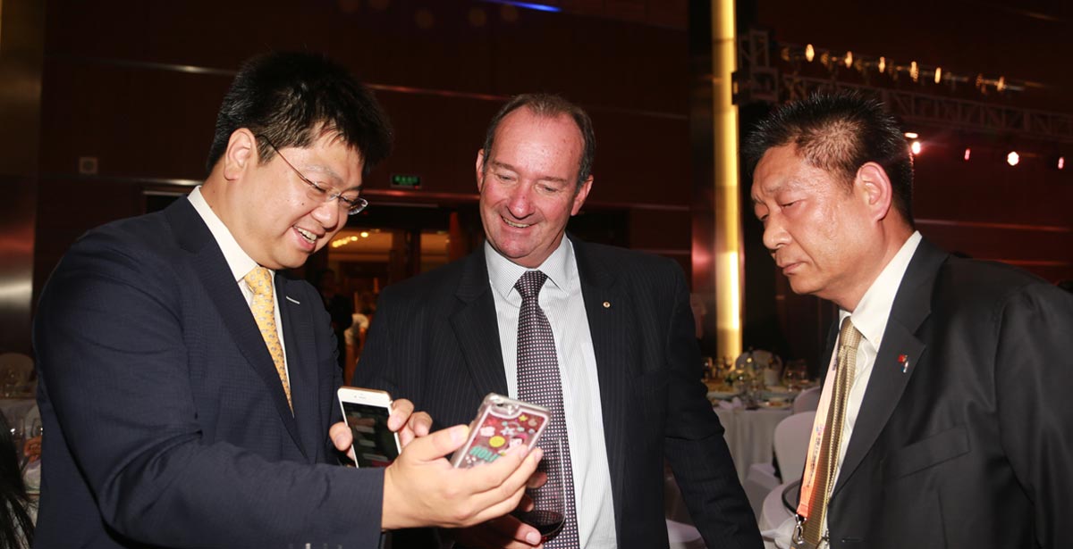 第四届京交会于5月28日开幕，图为大公报社长助理、大公网执行总裁兼总编辑王文韬（左一）向澳大利亚前副总理马克·维尔先生（中）介绍大公网对京交会的报道情况，马克·维尔先生兴致勃勃地观看了大公网在PC端、移动端，以及微博、微信上的直播。（大公网记者王萍/摄）